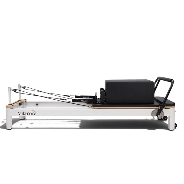Pearl Studio Original Pilates reformer, side view, white aluminium frame and black upholstery