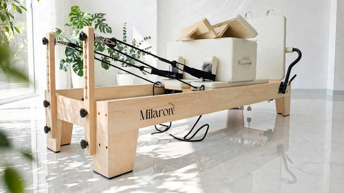 A Maple Studio Crème reformer in a bright room with plants and dappled sunlight on a marble floor